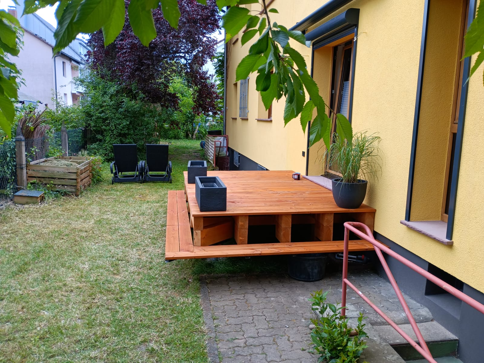 Neu gebaute, erhöhte Holzterrasse aus Douglasie mit breiter Einstiegsstufe im Garten